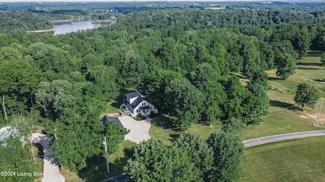 birds eye view of property with a water view and a wooded view