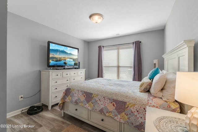 bedroom featuring baseboards and wood finished floors