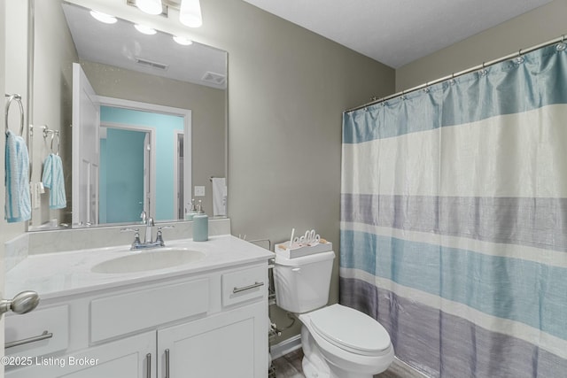 full bath with toilet, baseboards, visible vents, and vanity