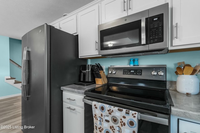 kitchen featuring light wood-style floors, white cabinetry, and appliances with stainless steel finishes