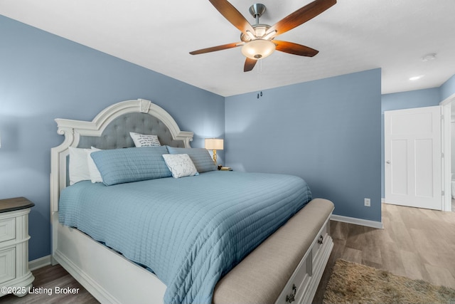 bedroom with ceiling fan, baseboards, and wood finished floors