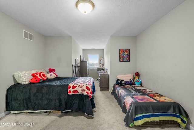 carpeted bedroom with visible vents and a textured ceiling