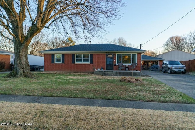 view of front of house with brick siding, aphalt driveway, and a front lawn