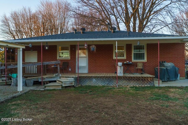 view of front of home with brick siding, a porch, and a front lawn