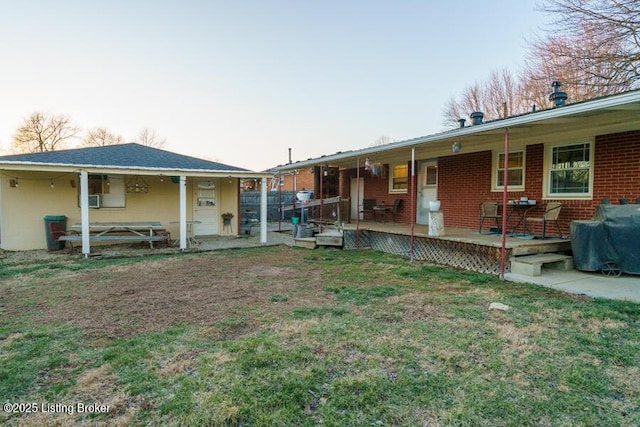 back of house with a yard, covered porch, and brick siding