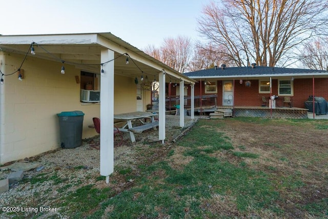 rear view of property with cooling unit and brick siding