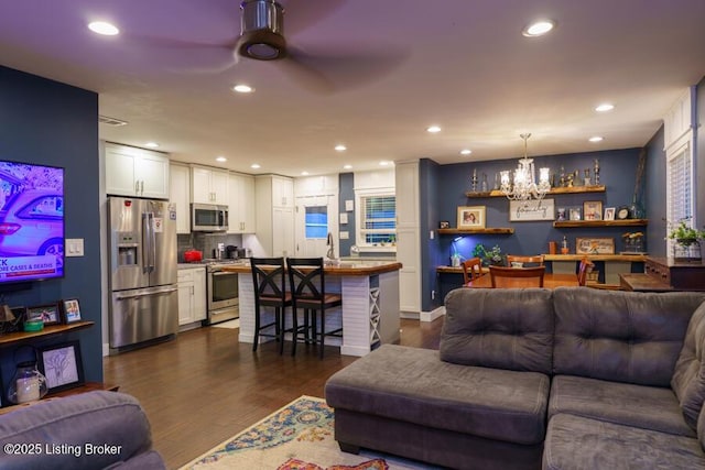 living room with recessed lighting, dark wood-type flooring, and ceiling fan