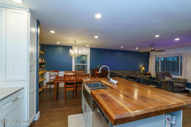 kitchen featuring recessed lighting, butcher block counters, white cabinetry, and stainless steel dishwasher