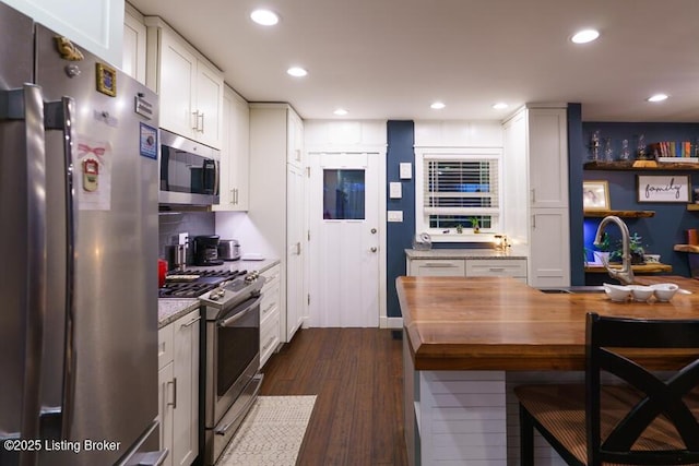 kitchen with a sink, dark wood-style floors, recessed lighting, stainless steel appliances, and butcher block counters