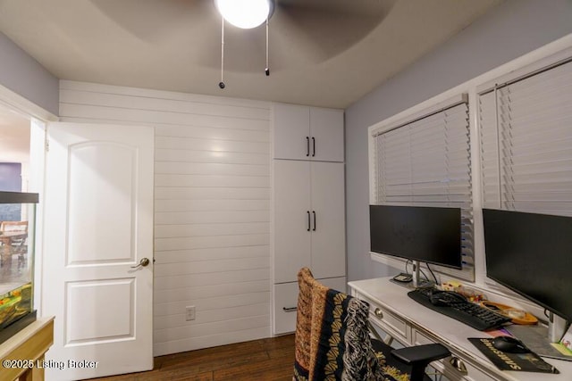 office area featuring dark wood-style floors, wood walls, and ceiling fan