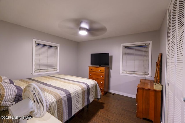 bedroom featuring a closet, a ceiling fan, baseboards, and wood finished floors