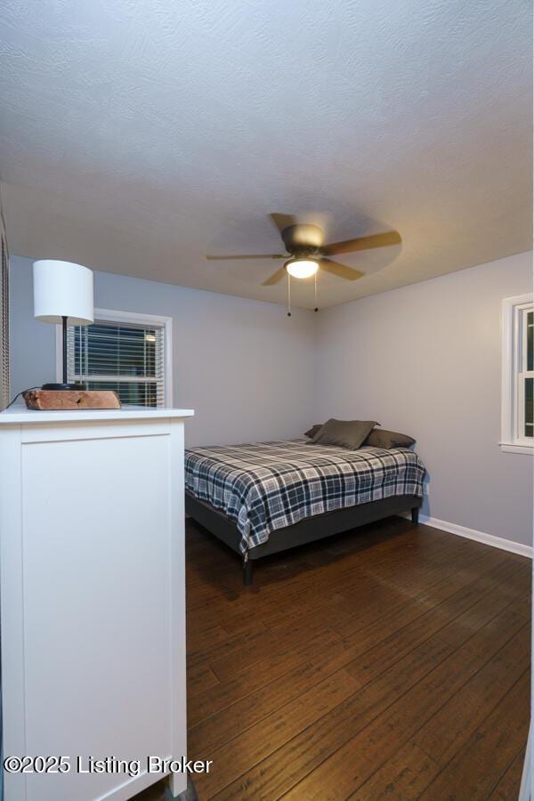 bedroom featuring baseboards, a textured ceiling, a ceiling fan, and hardwood / wood-style flooring