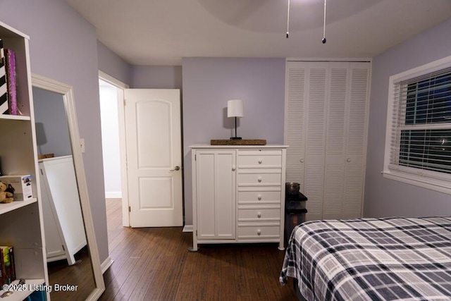 bedroom with a closet, dark wood-type flooring, and ceiling fan