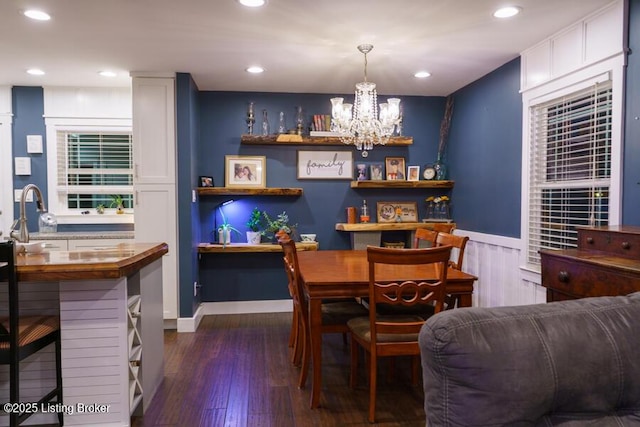 dining space with a wainscoted wall, recessed lighting, an inviting chandelier, and dark wood-style flooring