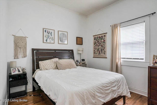 bedroom featuring ornamental molding, wood finished floors, and baseboards