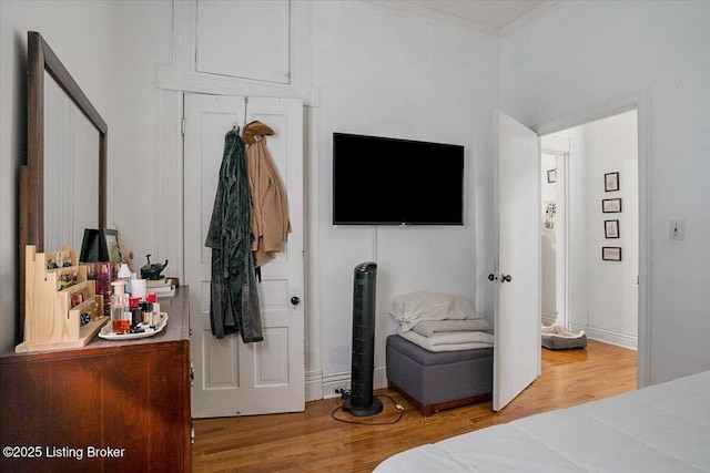 bedroom featuring crown molding and wood finished floors