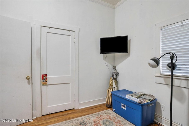 interior space featuring crown molding and wood finished floors