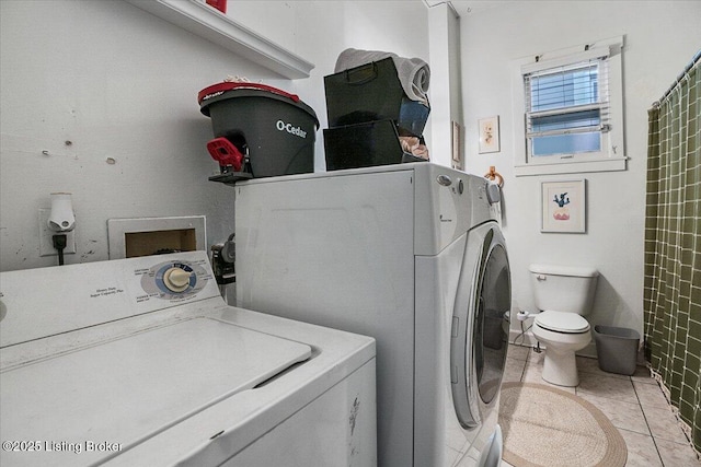 washroom featuring laundry area, separate washer and dryer, and light tile patterned floors