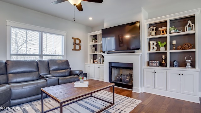 living area featuring recessed lighting, a fireplace, dark wood finished floors, and ceiling fan