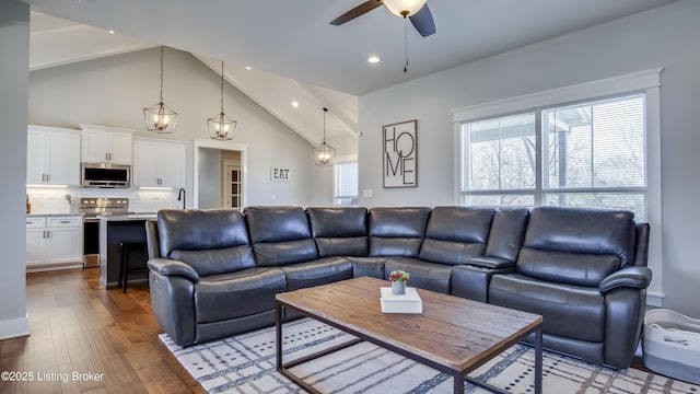 living room featuring ceiling fan, high vaulted ceiling, wood finished floors, and recessed lighting