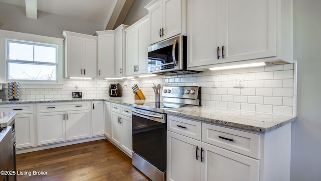 kitchen with appliances with stainless steel finishes, dark wood-style flooring, white cabinets, and tasteful backsplash