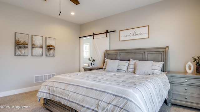 bedroom with carpet, recessed lighting, visible vents, a barn door, and baseboards