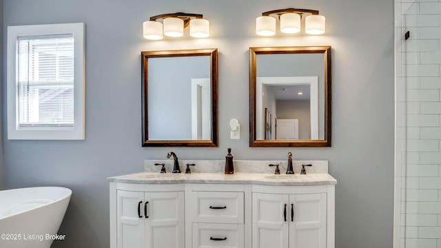 bathroom featuring double vanity, a freestanding bath, and a sink