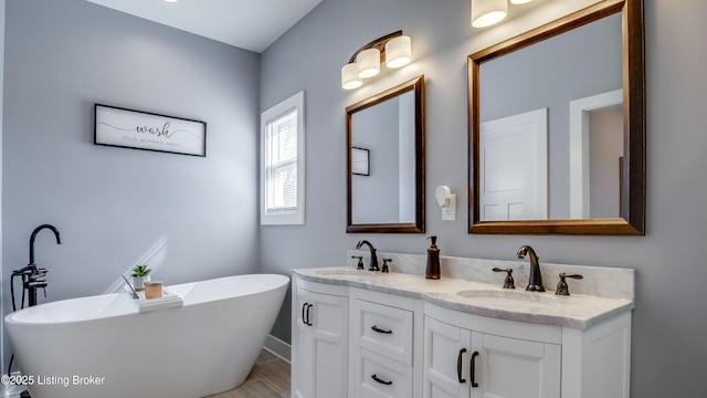 bathroom with double vanity, a soaking tub, and a sink