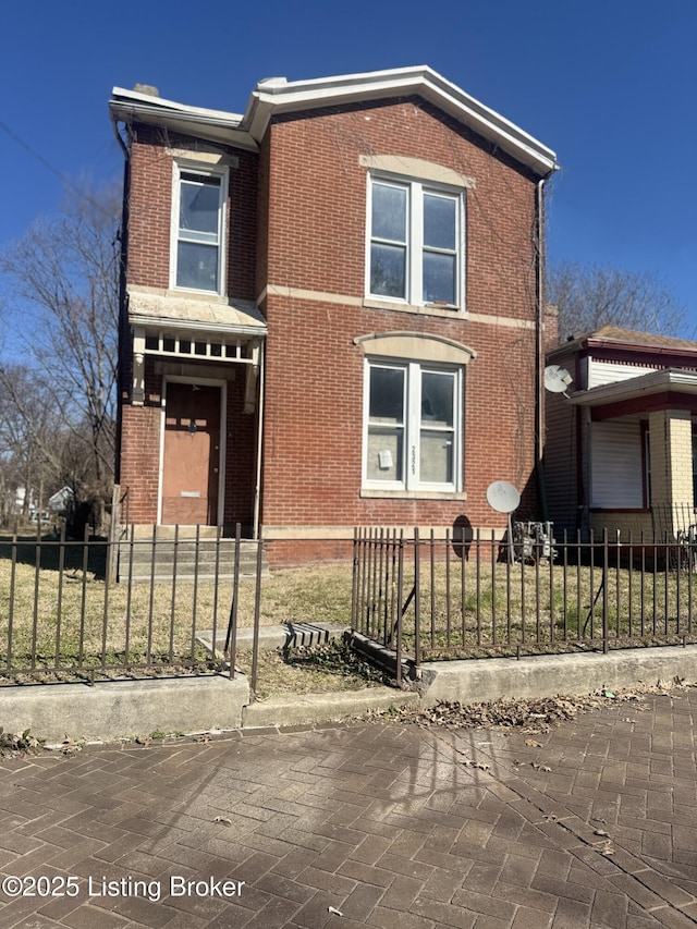 view of front of house with brick siding and a fenced front yard