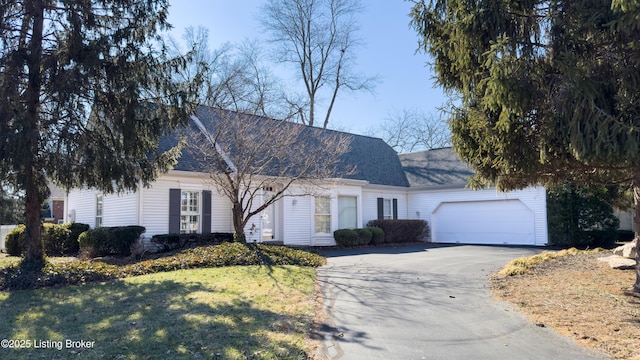 view of front of home with aphalt driveway, a front yard, a shingled roof, and an attached garage