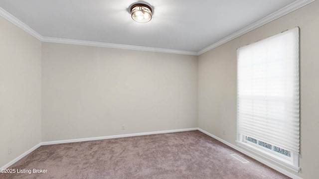 carpeted spare room with ornamental molding, visible vents, and baseboards