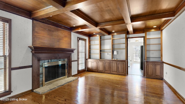 unfurnished living room with wooden ceiling, light wood-style flooring, coffered ceiling, and beam ceiling