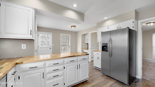 kitchen with a peninsula, butcher block counters, dark wood-type flooring, white cabinetry, and stainless steel fridge