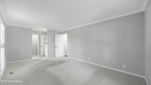 carpeted spare room featuring ornamental molding, visible vents, and baseboards