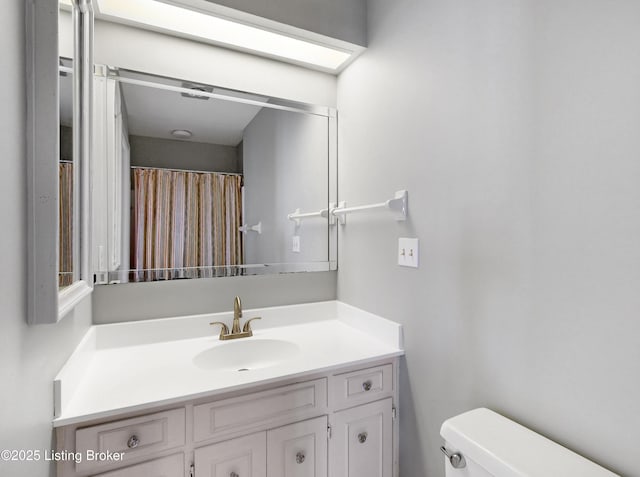 full bathroom with toilet and vanity