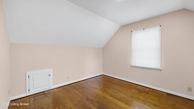 bonus room with visible vents, vaulted ceiling, baseboards, and wood finished floors