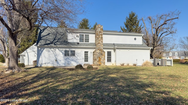 rear view of property with a chimney, fence, and a yard