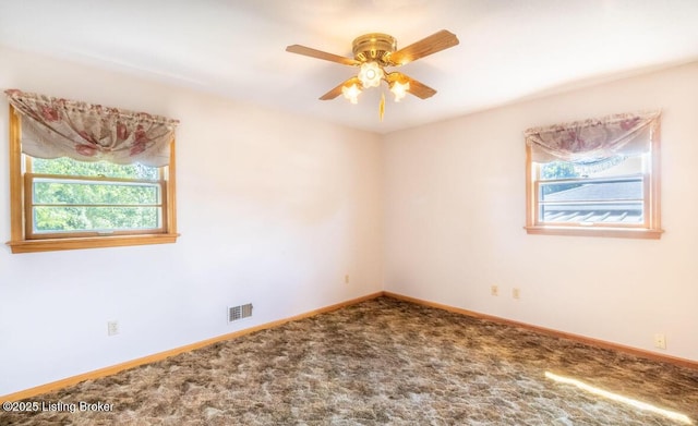 spare room with carpet floors, baseboards, visible vents, and ceiling fan