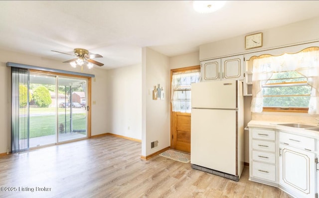 kitchen featuring visible vents, baseboards, light countertops, light wood-type flooring, and freestanding refrigerator