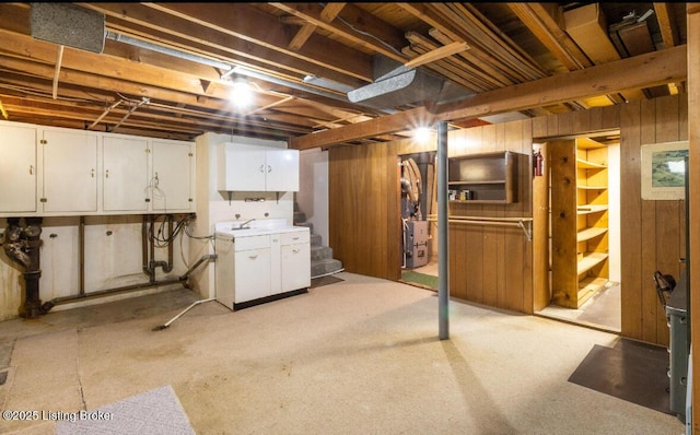 unfinished basement featuring stairs and wooden walls