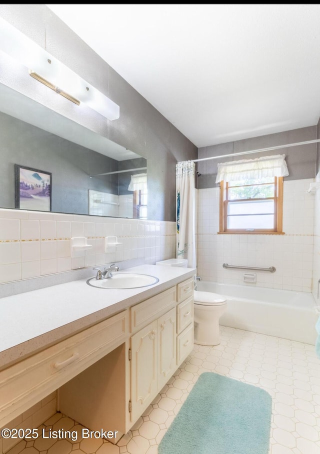 bathroom with toilet, vanity, tile walls, tile patterned floors, and shower / bath combo with shower curtain