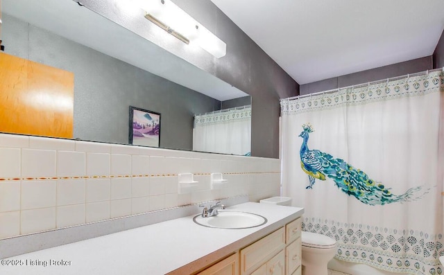 full bath featuring tile walls, tasteful backsplash, curtained shower, toilet, and vanity