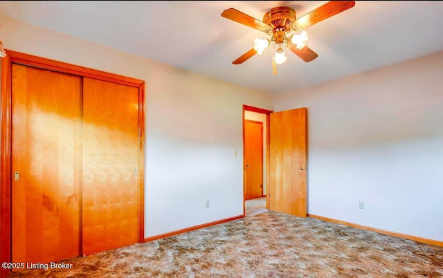 unfurnished bedroom with a closet, carpet, a ceiling fan, and baseboards