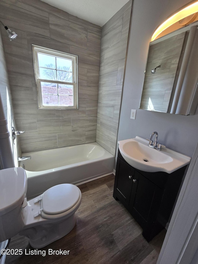 bathroom featuring toilet, bathtub / shower combination, wood finished floors, and vanity