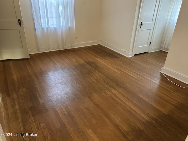 unfurnished bedroom with dark wood finished floors and baseboards