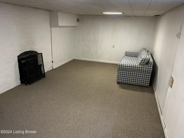 finished basement featuring carpet floors, a paneled ceiling, and baseboards