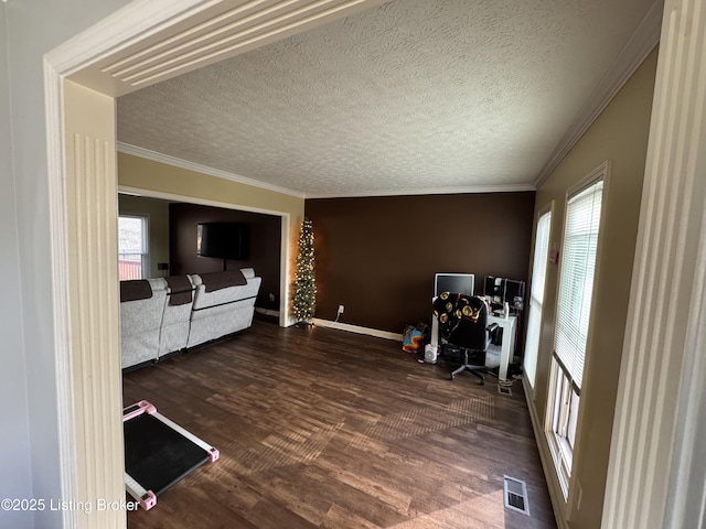 living area featuring a wealth of natural light, wood finished floors, visible vents, and crown molding