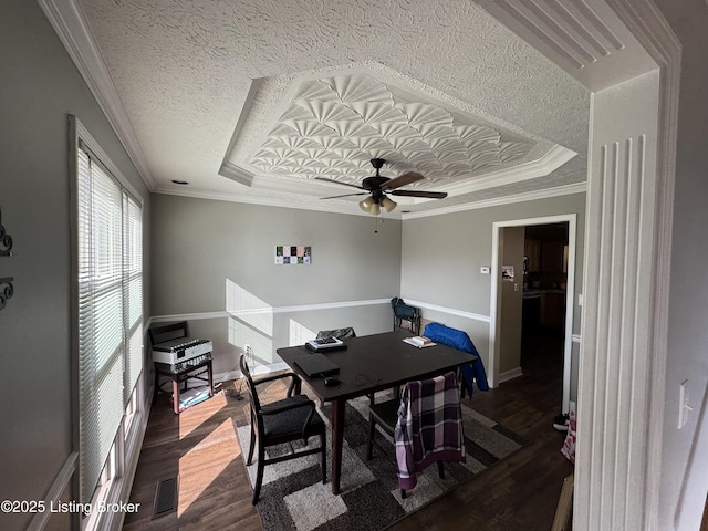 dining area featuring a raised ceiling, visible vents, crown molding, and wood finished floors