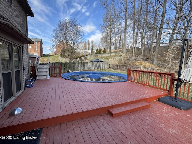 wooden terrace with a fenced backyard