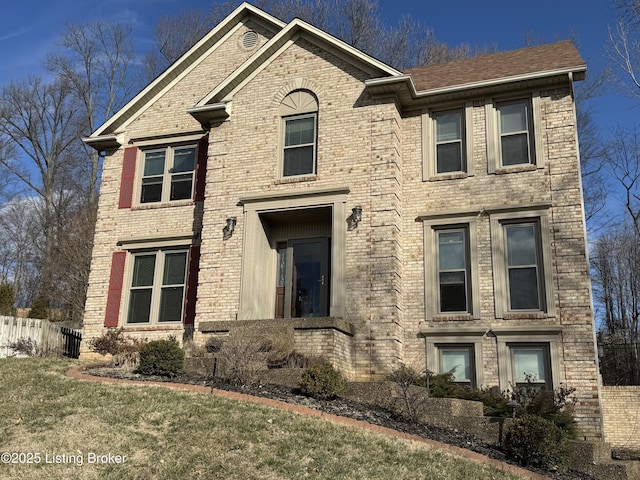 view of front of property with fence, a front lawn, and brick siding